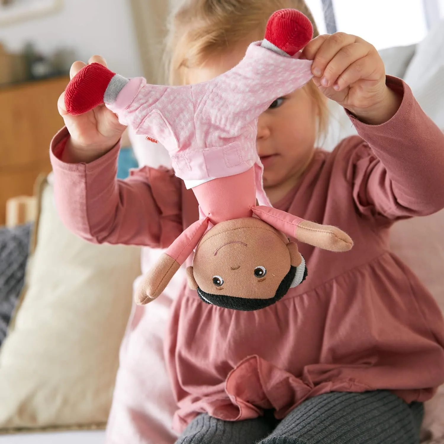 HABA Snug Up Doll Rumbi - 10" Soft Doll with Black Hair and Pink Overalls - Machine Washable for 18 Months and Up